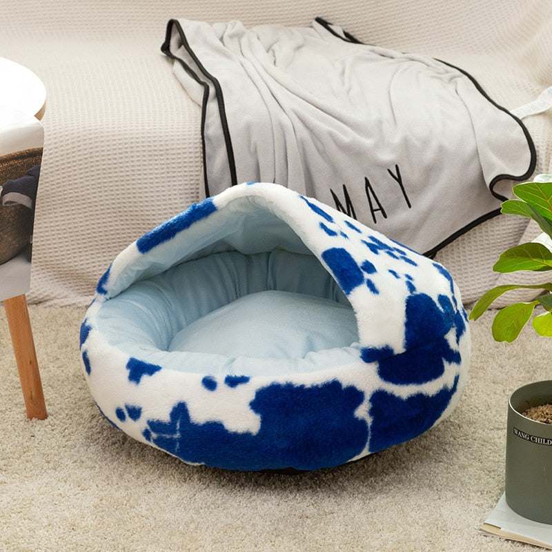 Blue and white plush pet cat bed with cozy enclosed design on carpeted floor