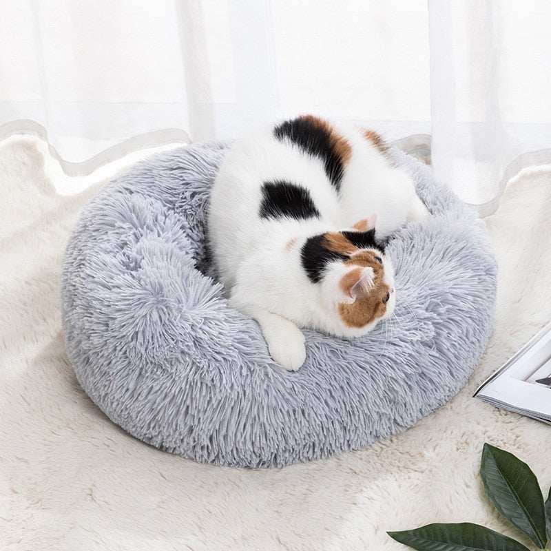 Calming pet bed gray fluffy donut shape with cat resting for anxiety relief and comfort