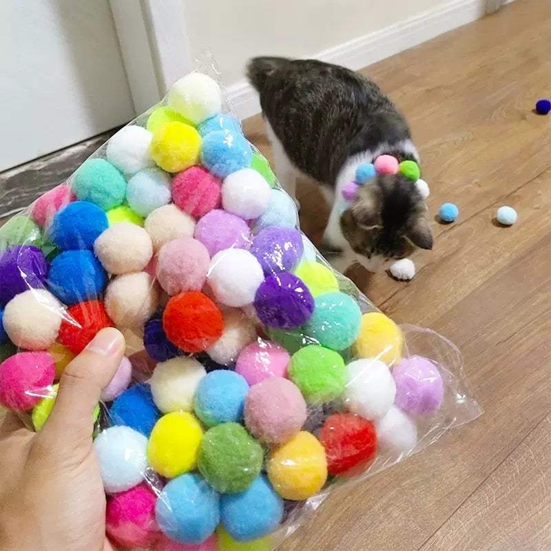 Colorful plush balls for Cat Plush Silent Ball Gun interactive toy with cat playing nearby on wooden floor